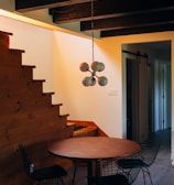 round brown wooden table and chairs under white pendant lamp