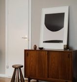 a room with a wooden cabinet and a picture on the wall
