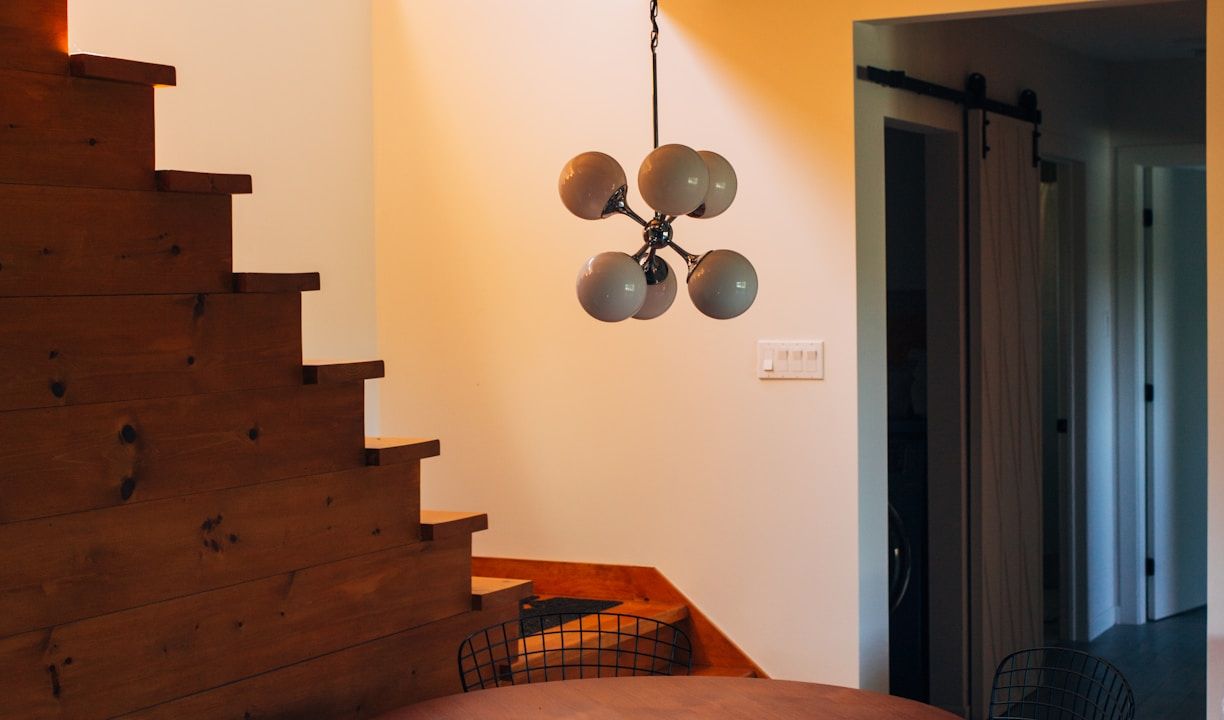 round brown wooden table and chairs under white pendant lamp